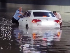 终于了解洛阳大雨致司机被困 交警挽起裤子帮忙推车